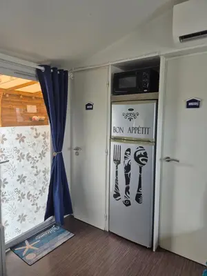 a room with a kitchen with a door with a iron appliance at Mobil-home Climatisé 6 personnes à Port La Nouvelle in Port-la-Nouvelle