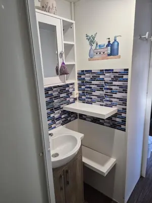 a bathroom with a sink and a mirror at Mobil-home Climatisé 6 personnes à Port La Nouvelle in Port-la-Nouvelle
