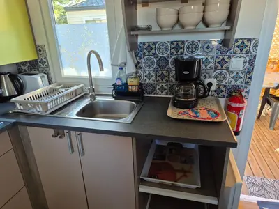a small kitchen with a sink and a counter top at Mobil-home Climatisé 6 personnes à Port La Nouvelle in Port-la-Nouvelle