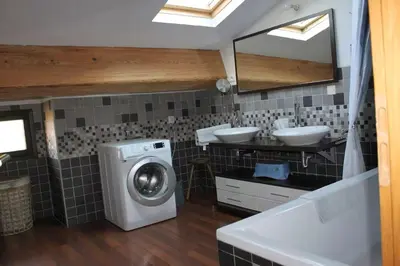 a bathroom with a washing machine and two sinks at La Galinette Family Loft in Sigean