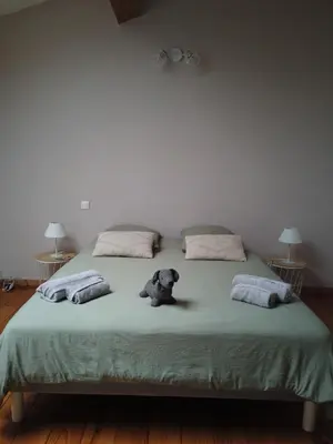 a teddy bear sitting on a bed with pillows at La Galinette Family Loft in Sigean
