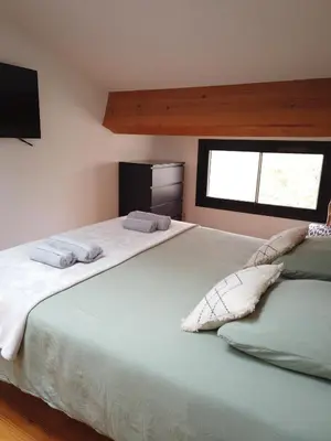 a bedroom with a large bed with two pillows on it at La Galinette Family Loft in Sigean
