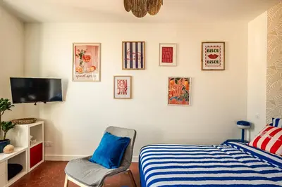 a bedroom with a bed and a chair at Studio Blue Délice in Narbonne