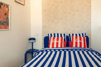a bedroom with a bed with blue and white stripes at Studio Blue Délice in Narbonne