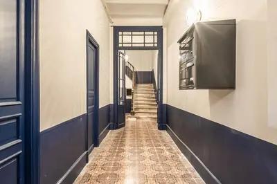 a hallway with a door and a tiled floor at Studio Blue Délice in Narbonne