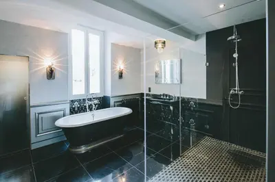 a black bathroom with a tub and a shower at Chateau de Paraza in Paraza