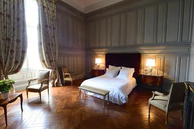 a bedroom with a bed and two chairs and a window at Chateau de Paraza in Paraza