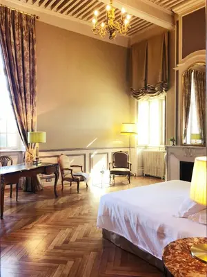 a bedroom with a bed and a desk and chairs at Chateau de Paraza in Paraza