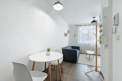 a small living room with a white table and chairs at T2 apartment in the heart of Cuxac-d'Aude in Cuxac-dʼAude