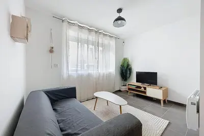 a living room with a couch and a tv at T2 apartment in the heart of Cuxac-d'Aude in Cuxac-dʼAude