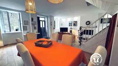 a dining room with an orange table and chairs at Le moulin de cameliere in Caudebronde