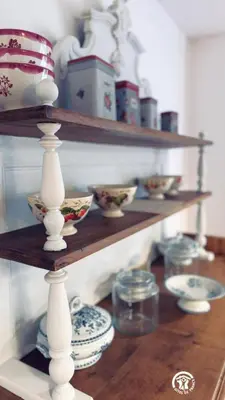 a shelf with plates and bowls on a wooden table at Le moulin de cameliere in Caudebronde