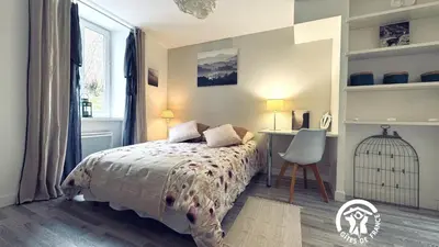 a bedroom with a bed and a desk and a chair at Le moulin de cameliere in Caudebronde