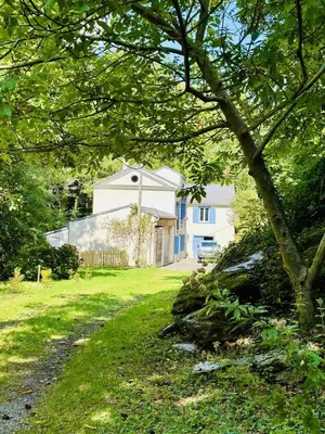a white house in a yard with a tree at Le moulin de cameliere in Caudebronde