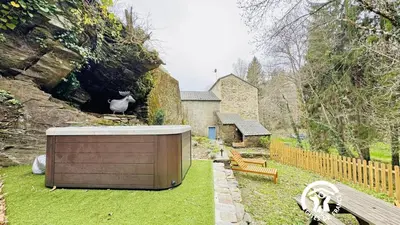 a cat sitting on top of a wooden box in a yard at Le moulin de cameliere in Caudebronde
