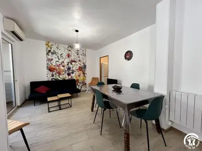 a living room with a dining room table and a couch at Chez madou in Roquefort-des-Corbières