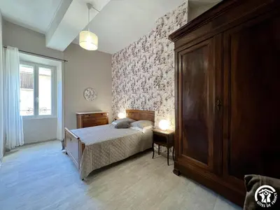 a bedroom with a bed and a dresser and a window at Chez madou in Roquefort-des-Corbières