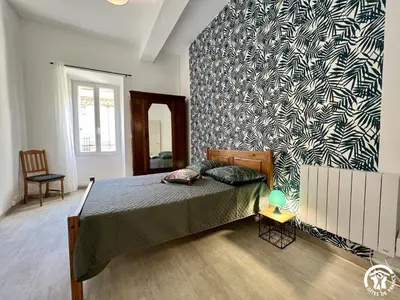 a bedroom with a bed and a black and white wall at Chez madou in Roquefort-des-Corbières