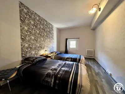 two beds in a room with a wall at Chez madou in Roquefort-des-Corbières