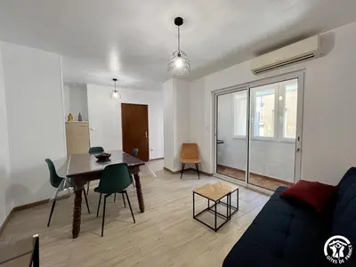 a living room with a couch and a table and chairs at Chez madou in Roquefort-des-Corbières