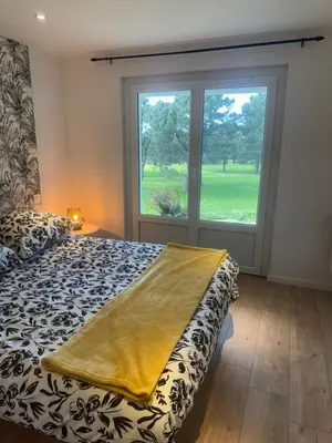 a bedroom with a bed and a window at Appartement au cœur du golf in Pont-de-Larn