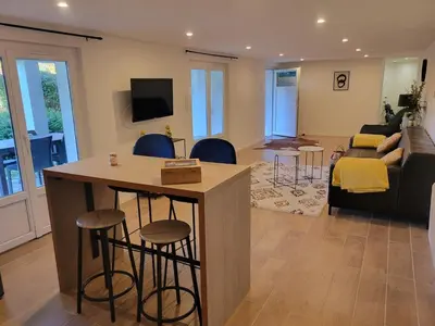 a living room with a kitchen and a living room with a couch at Appartement au cœur du golf in Pont-de-Larn