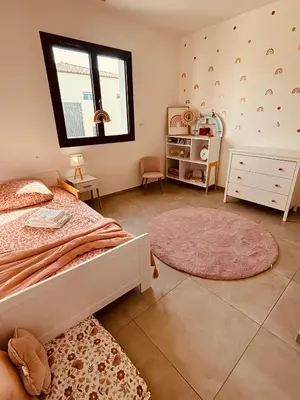 a bedroom with a bed and a window and a rug at Villa moderne privée avec piscine, vue montagne 3 chambres in Pennautier