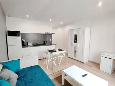 a living room with a couch and a kitchen at Le Secret du Clocher in Pamiers