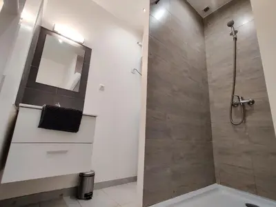 a bathroom with a shower with a mirror at Le Secret du Clocher in Pamiers