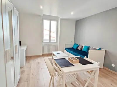 a living room with a blue couch and a table at Le Secret du Clocher in Pamiers