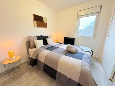 a bedroom with a large bed and a window at Le Faubourg in Pamiers