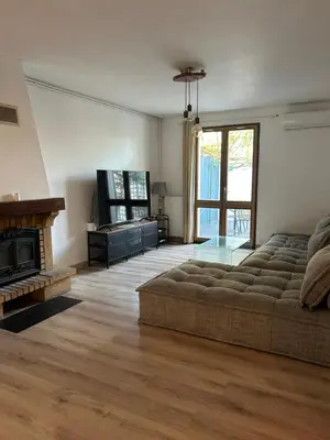 a living room with a couch and a fireplace at Maison 3 chambres, piscine privée terrain de pétanque in Carcassonne