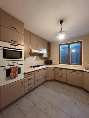 a large kitchen with white appliances and a window at Maison 3 chambres, piscine privée terrain de pétanque in Carcassonne