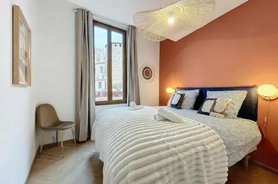 a bedroom with a large bed and a window at Le Saint Just - Appartement face à la Cathédrale in Narbonne
