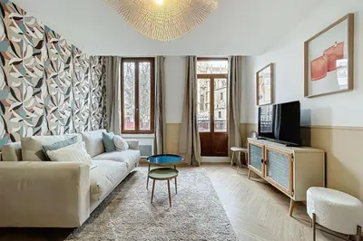 a living room with a couch and a tv at Le Saint Just - Appartement face à la Cathédrale in Narbonne