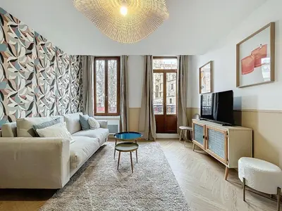 a living room with a couch and a tv at Le Saint Just - Appartement face à la Cathédrale in Narbonne