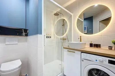 a bathroom with a sink and a washing machine at Le Saint Just - Appartement face à la Cathédrale in Narbonne