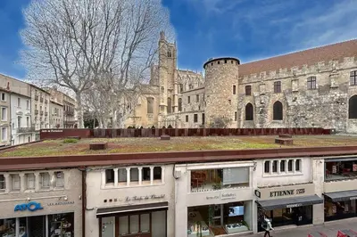 an old building with a church in the background at Le Saint Just - Appartement face à la Cathédrale in Narbonne
