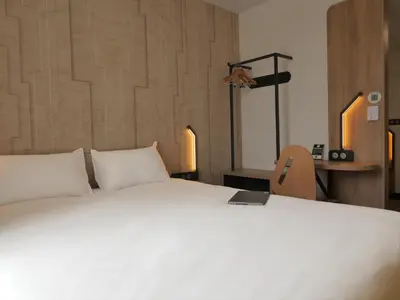 a bedroom with a white bed with a laptop on it at B&B HOTEL Carcassonne Rocadest La Cité in Carcassonne