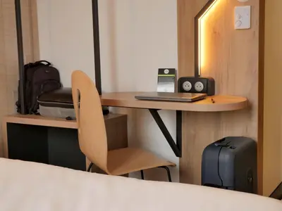 a room with a desk with a laptop and a chair at B&B HOTEL Carcassonne Rocadest La Cité in Carcassonne