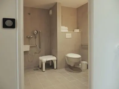 a bathroom with a toilet and a stool in it at B&B HOTEL Carcassonne Rocadest La Cité in Carcassonne