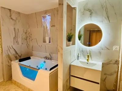 a bathroom with a tub and a sink at Sereni house jacuzzi in Narbonne