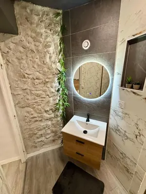 a bathroom with a sink and a mirror at Sereni house jacuzzi in Narbonne