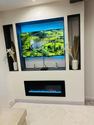 a living room with a tv above a fireplace at Sereni house jacuzzi in Narbonne