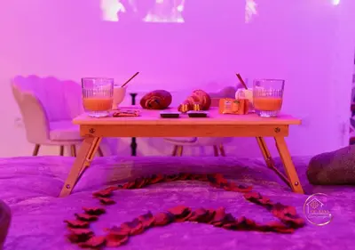 a table in a room with two glasses and a purple room at Le bridgerlove Tantra Jacuzzi Unique in Quillan