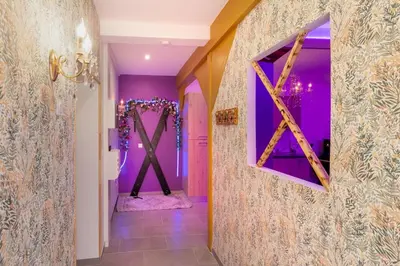 a hallway with purple walls and a mirror at Le bridgerlove Tantra Jacuzzi Unique in Quillan