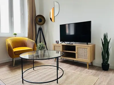 a living room with a tv and a glass table at L'atypique l 2 chambres l Clim in Castres
