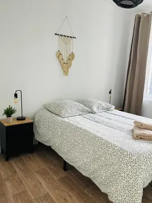 a bedroom with a bed and a table and a window at L'atypique l 2 chambres l Clim in Castres