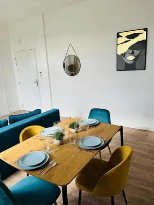a wooden table with chairs and plates on it at L'atypique l 2 chambres l Clim in Castres