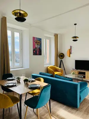 a living room with a blue couch and a table at L'atypique l 2 chambres l Clim in Castres